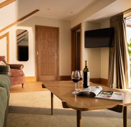 A living room with a coffee table and a wine bottle at Trevean in Mullion