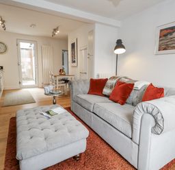 A living room with a sofa and dining area at Fisherman’s Cottage
