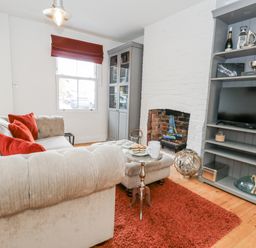 A living room with a sofa and television at Fisherman’s Cottage
