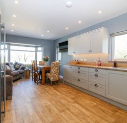 A kitchen with a table and chairs next to a sofa at Tirionfa in Talsarnau
