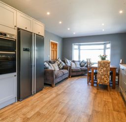 A kitchen with appliances and seating at Tirionfa in Talsarnau