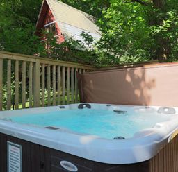 A hot tub on a wooden deck at Lodge 68 - Fern Gully near Finlakes Holiday Park in Chudleigh