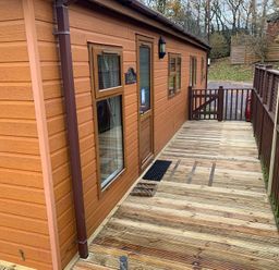 An outdoor area with a wooden cabin and deck at Woodland View 31 - The Hawthorns Finlakes Holiday Park near Chudleigh