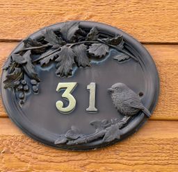 A house number plaque with a bird and leaves at Woodland View 31 - The Hawthorns Finlakes Holiday Park near Chudleigh