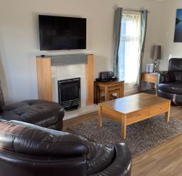 A living room with a fireplace and television at Woodland View 31 - The Hawthorns near Chudleigh