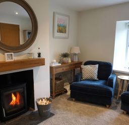 A living room with armchairs and a fireplace at Glendale Trelights near Port Isaac