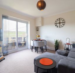 A living room with a sofa and dining table at Golygfa in Pandy Tudur near Llanrwst
