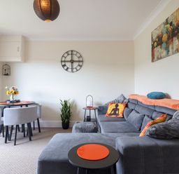 A living room with a sofa and dining area at Golygfa near Pandy Tudur