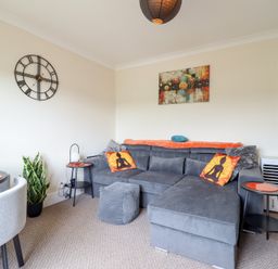A living room with a sofa and a dining table at Golygfa in Pandy Tudur near Llanrwst