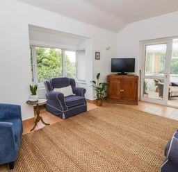 A living room with sofas and a television at Llain in Cardigan