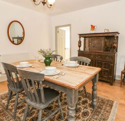 A dining room with a table and chairs at Llain in Cardigan