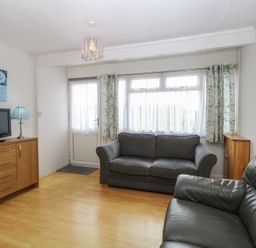 A living room with a sofa and a TV cabinet at 440 California Sands