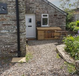 An outdoor area with a door and seating at Puffin Cottage in Tintagel