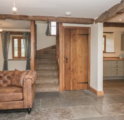 A living room with a couch and stairs at Howgill Head in Kendal