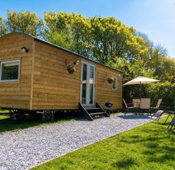 A tiny house with outdoor seating and a grill at Buzzards Lodge near Victoria