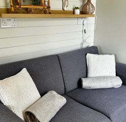 A sofa with cushions and a blanket at Buzzards Lodge near Victoria