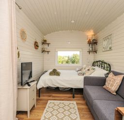 A living room with sofa and television at Buzzards Lodge in Roche