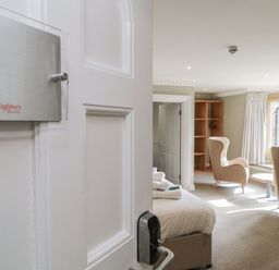 A bedroom with a bed and chairs at Chudleigh Charm in Chudleigh