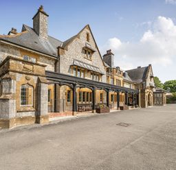 An exterior view of a stone building with a porch at Harcombe House Rooms - First Floor Twin in Chudleigh