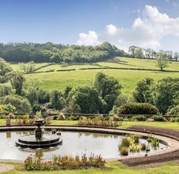A fountain surrounded by grass and plants at Harcombe House Rooms - First Floor Twin Chudleigh