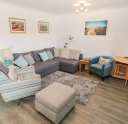 A living room with seating and decor at Puffin Nook in Broad Haven