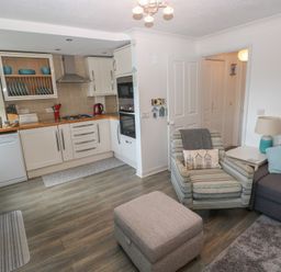 A kitchen and living room area with furniture at Puffin Nook Broad Haven