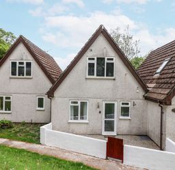 A row of three connected houses with triangular roofs and white walls at 23 Valley Lodge in Gunnislake
