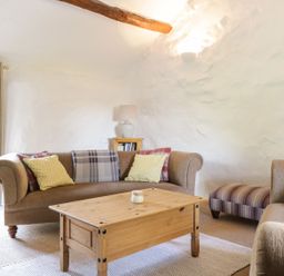 A living room with a sofa and coffee table at Cyffdy Cottage - Arenig in Bala