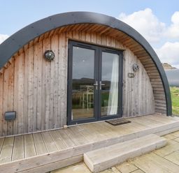 A wooden curved pod with glass double doors and a small wooden porch at Erraid in South Cuan near Cullipool Isle Of Luing