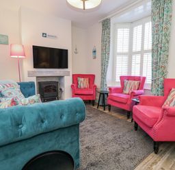 A living room with seating and a television at Shrimp Cottage in Brewers Quay Harbour