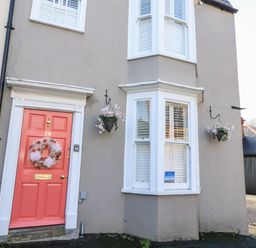 An entrance with a pink door and window at Shrimp Cottage, Brewers Quay Harbour