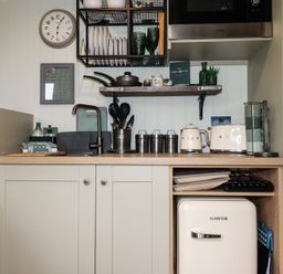 A small kitchen area with a sink utensils appliances and a mini fridge at The Highwood Hut near Liskeard