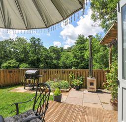 A garden patio with a barbecue grill and plants at The Highwood Hut near Liskeard
