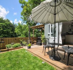 An outdoor space with a table and chairs under an umbrella at The Highwood Hut near Liskeard