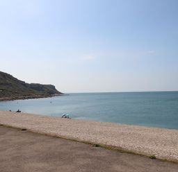 A beach with pebbles and cliffs near the sea at Lily's Pad in Weston, Portland