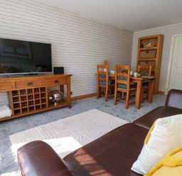 A living room with a television and a dining table at Lily's Pad in Weston, Portland