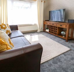 A living room with a sofa and television at Lily's Pad in Weston, Portland