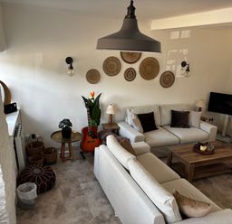 A living room with a sofa, coffee table, and television at Bracken Cottage in Osmington