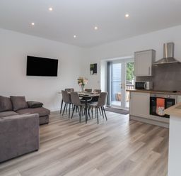 A living room with a sofa and dining area at Birch Cottage in Scarborough