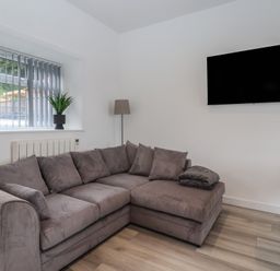 A living room with a sofa and television at Birch Cottage in Scarborough