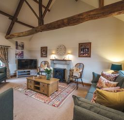 A living room with wooden beams a coffee table and sofas at Beaver Cottage in Little Thirkleby near Thirsk