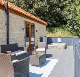 A deck with chairs and a hot tub at Castle View in Scarborough