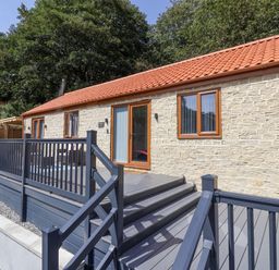 An outdoor area with a cottage and deck at Woodside in Scarborough