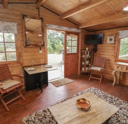 A cabin living area with chairs and a table at Carps Well Lodge Hatton near Shrewley