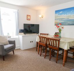 A dining room with a table and chairs at Driftwood in Weymouth