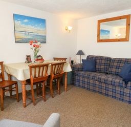 A dining room with table and chairs at Driftwood in Weymouth