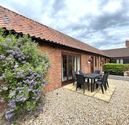 An outdoor area with a table and chairs at Beechwood in Wood Norton near Foulsham