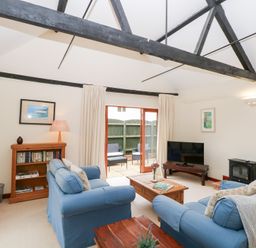 A living room with furniture and a television at Willow near Wood Norton