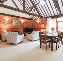 A living room with a sofa and dining table at Pear Tree in Wood Norton
