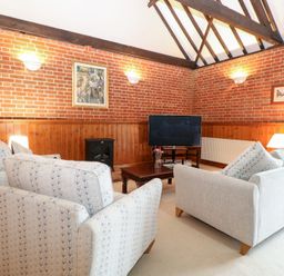 A living room with sofas and a television at Pear Tree in Wood Norton